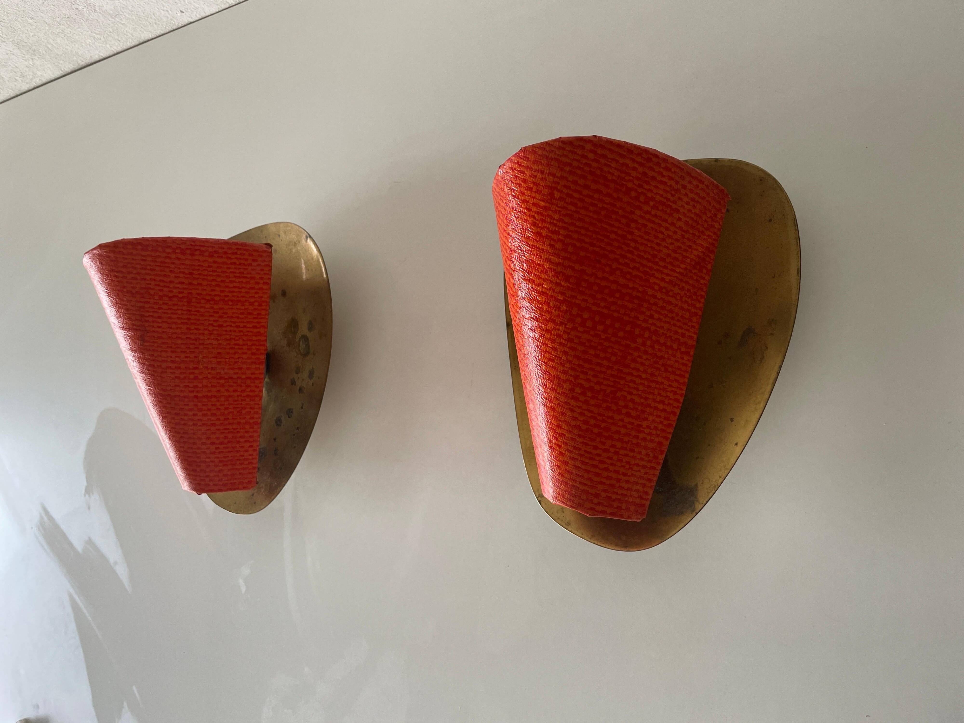 Pair of orange plexiglass and curved brass wall lights, 1950s, Germany
