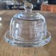 2 transparent glass butter dishes with their matching cloches.