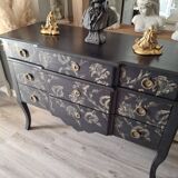 Large black chest of drawers with golden floral decoration