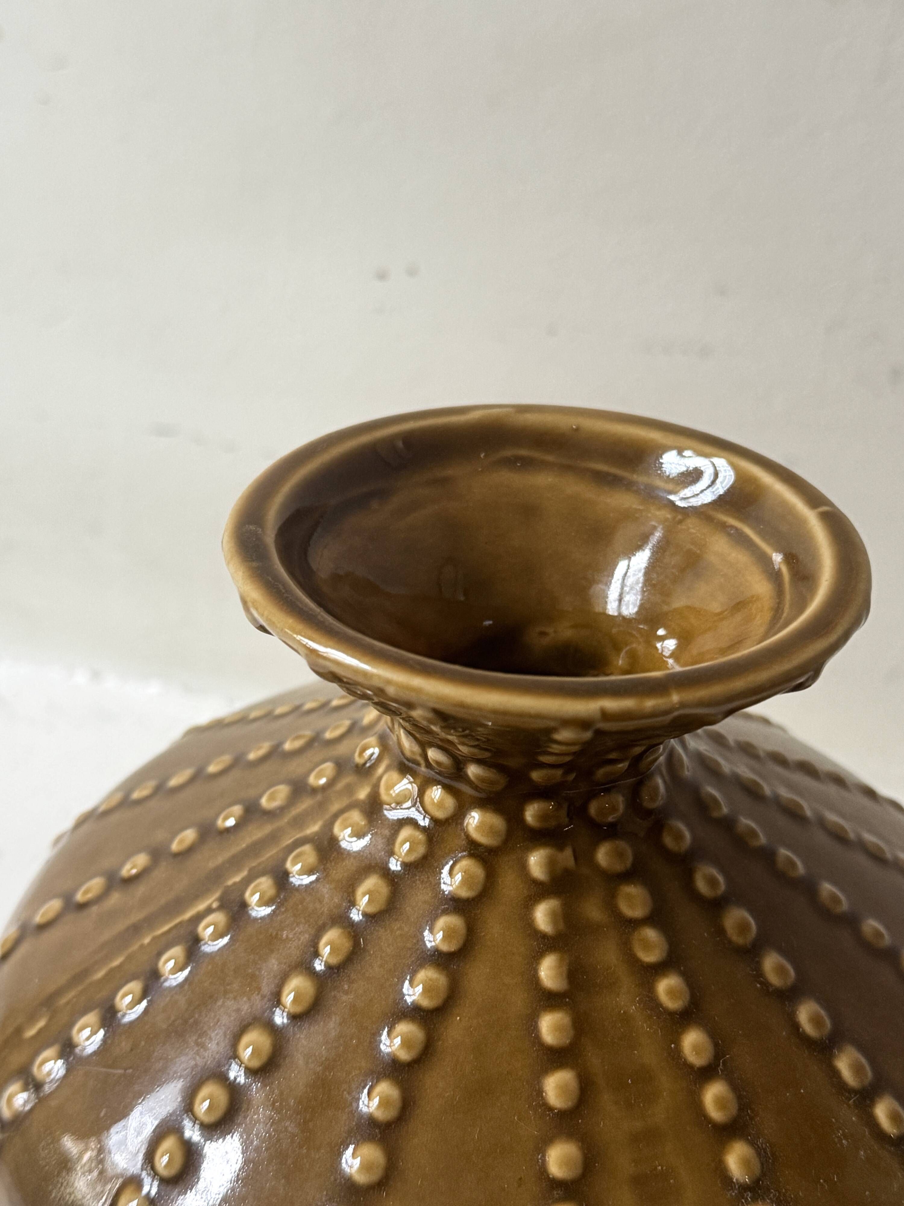 Pyriform vase in glazed ochre ceramic and beads.