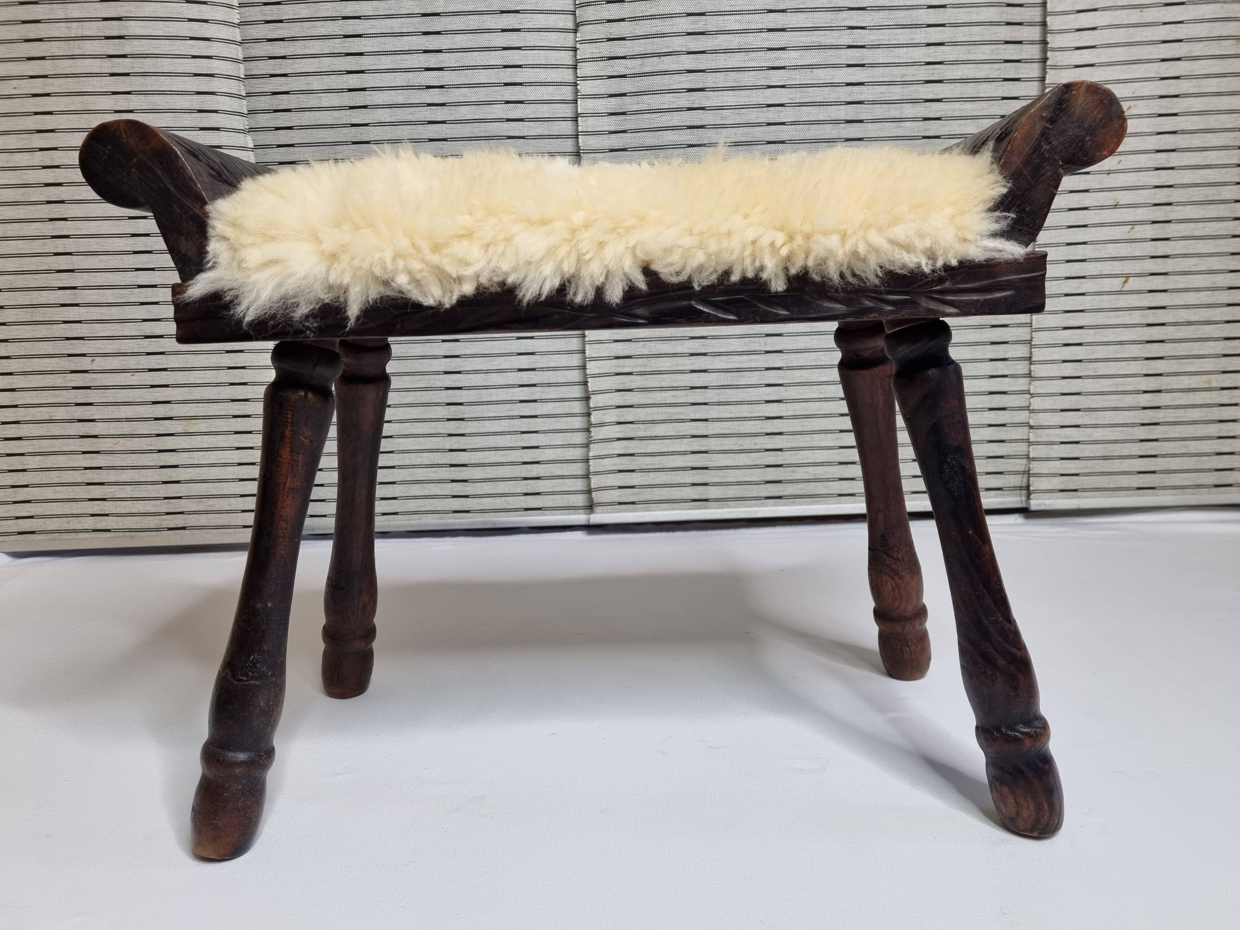 Carved wooden stool covered with Celtic-style sheepskin