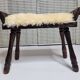 Carved wooden stool covered with Celtic-style sheepskin