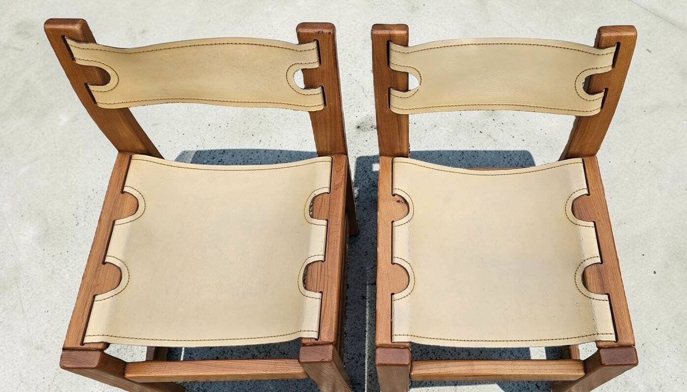 Pair of elm and leather chairs by Maison Regain