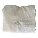 Damask tablecloth with a floral pattern and a central embroidered monogram.