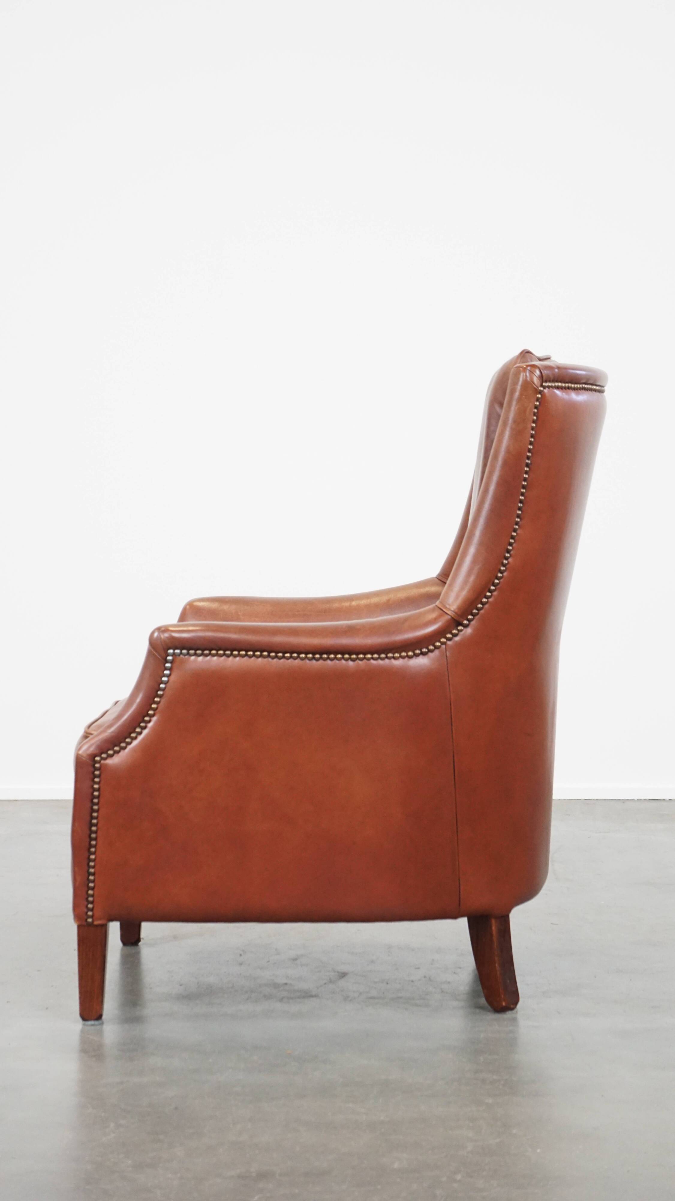 Cowhide armchair in good condition, finished with decorative nails