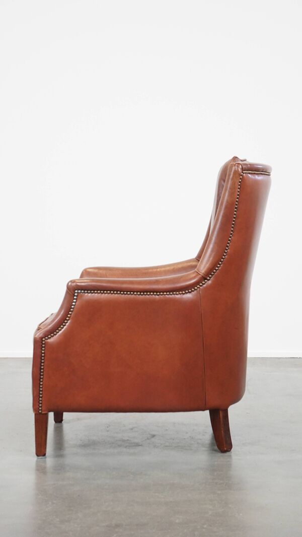 Fauteuil en cuir de vache en bon état, finition avec des clous décoratifs