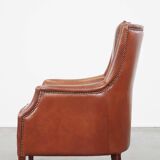 Cowhide armchair in good condition, finished with decorative nails