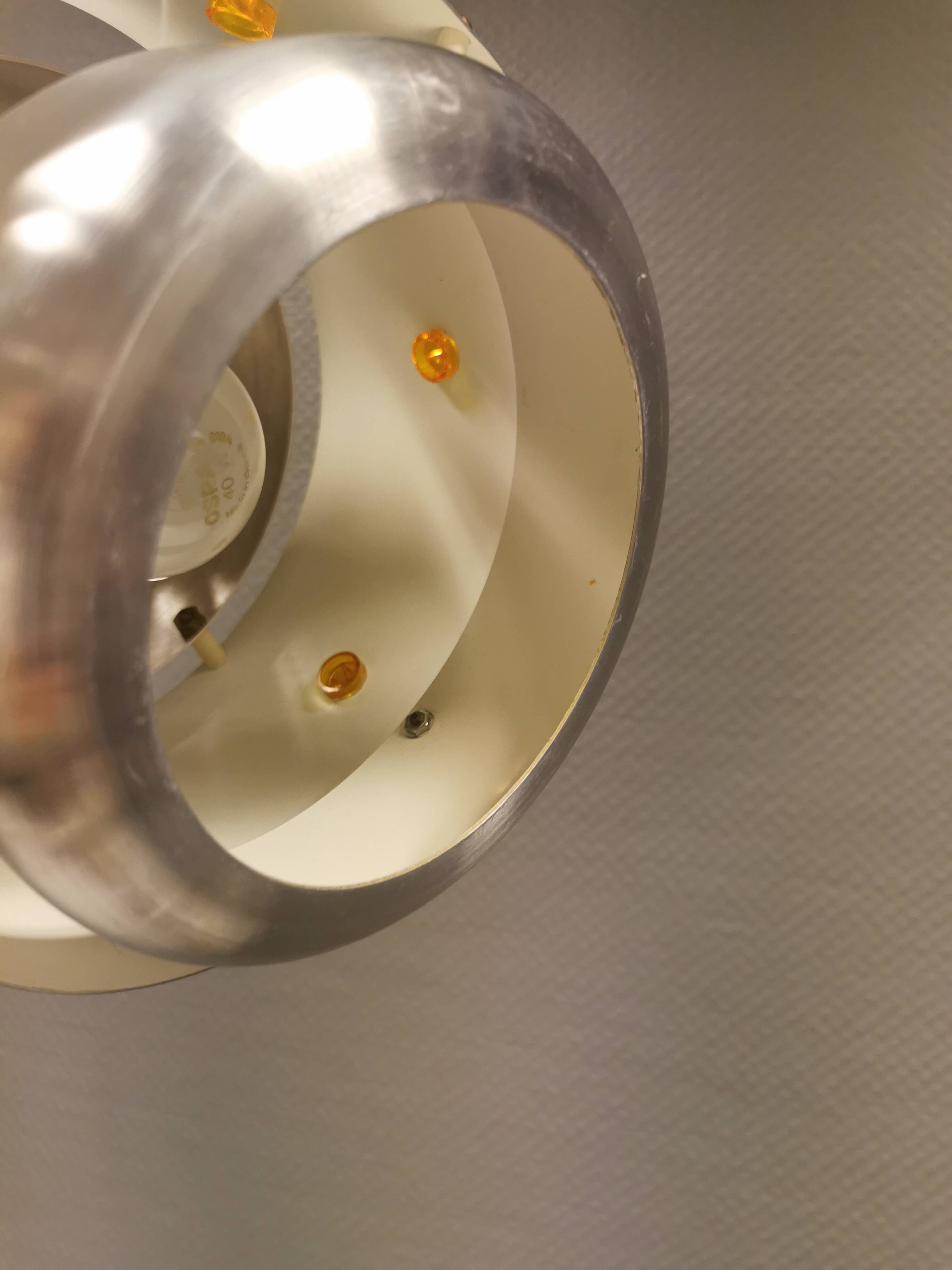 Two Space-Age hanging lamps, in silver-coloured aluminium with orange prisms.
