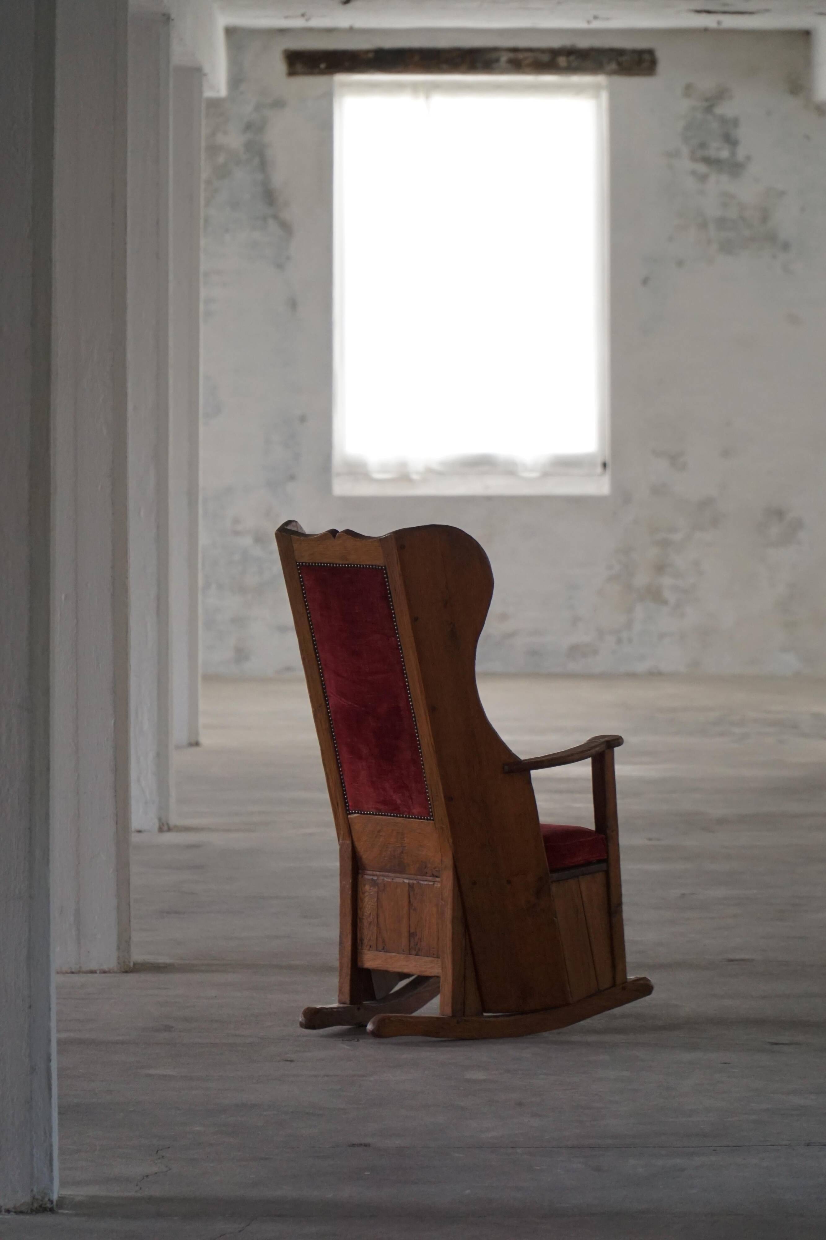 Antique English rocking chair in wood with red velvet upholstery, 19th century.
