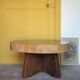 Brutalist wooden coffee table, cruciform leg with a tree trunk top.