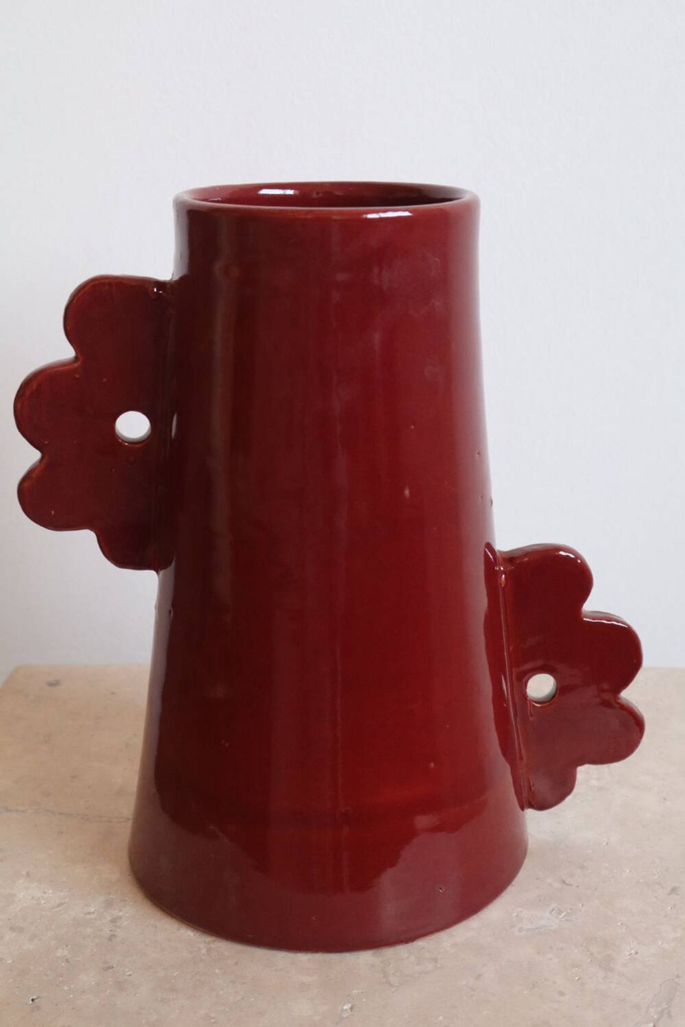 Handmade abstract ceramic vase with asymmetrical handles and burgundy flower