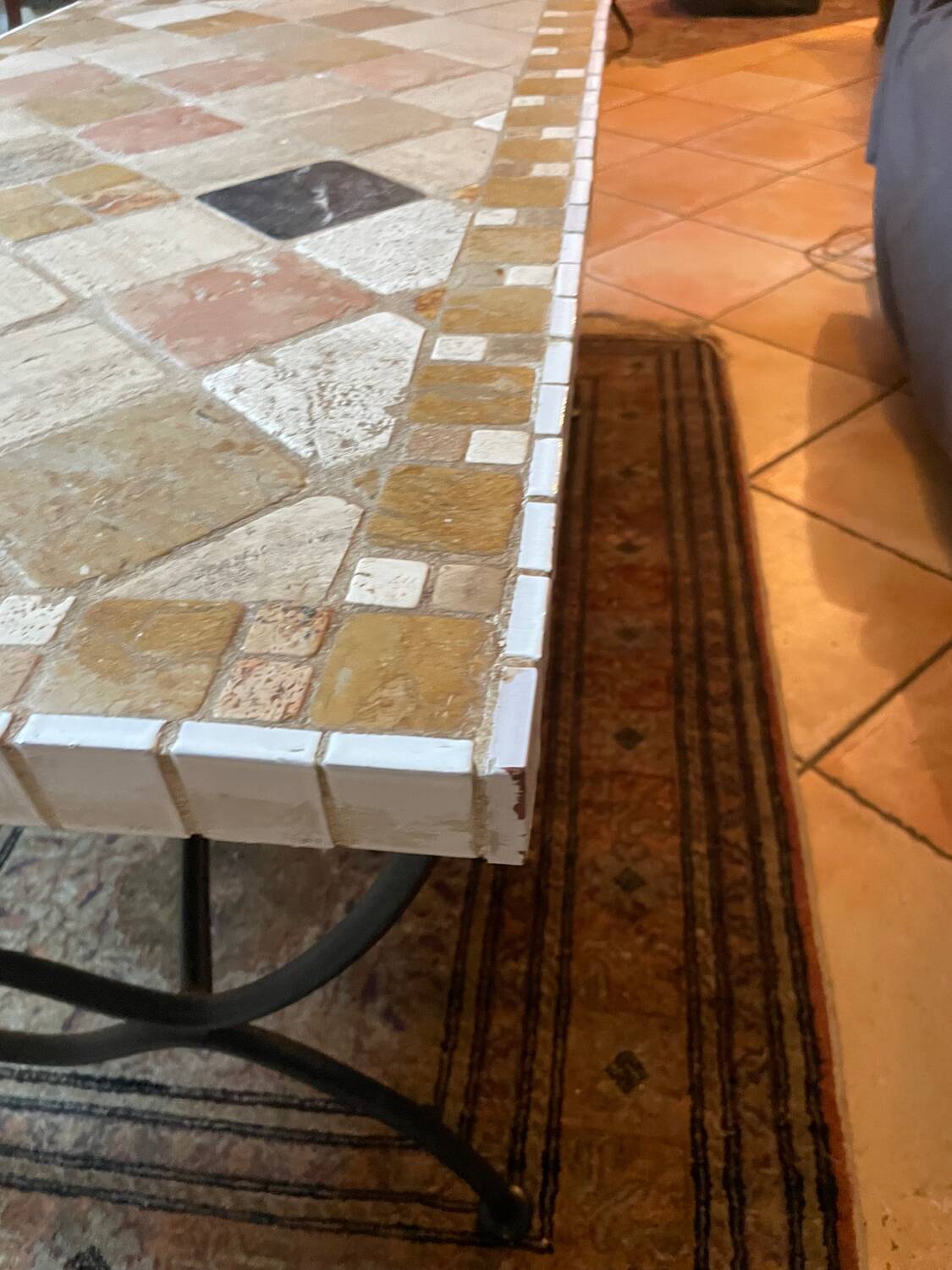 Beige ceramic coffee table with black metal legs.