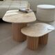 Oval coffee table duo travertine and raw fluted wooden legs.