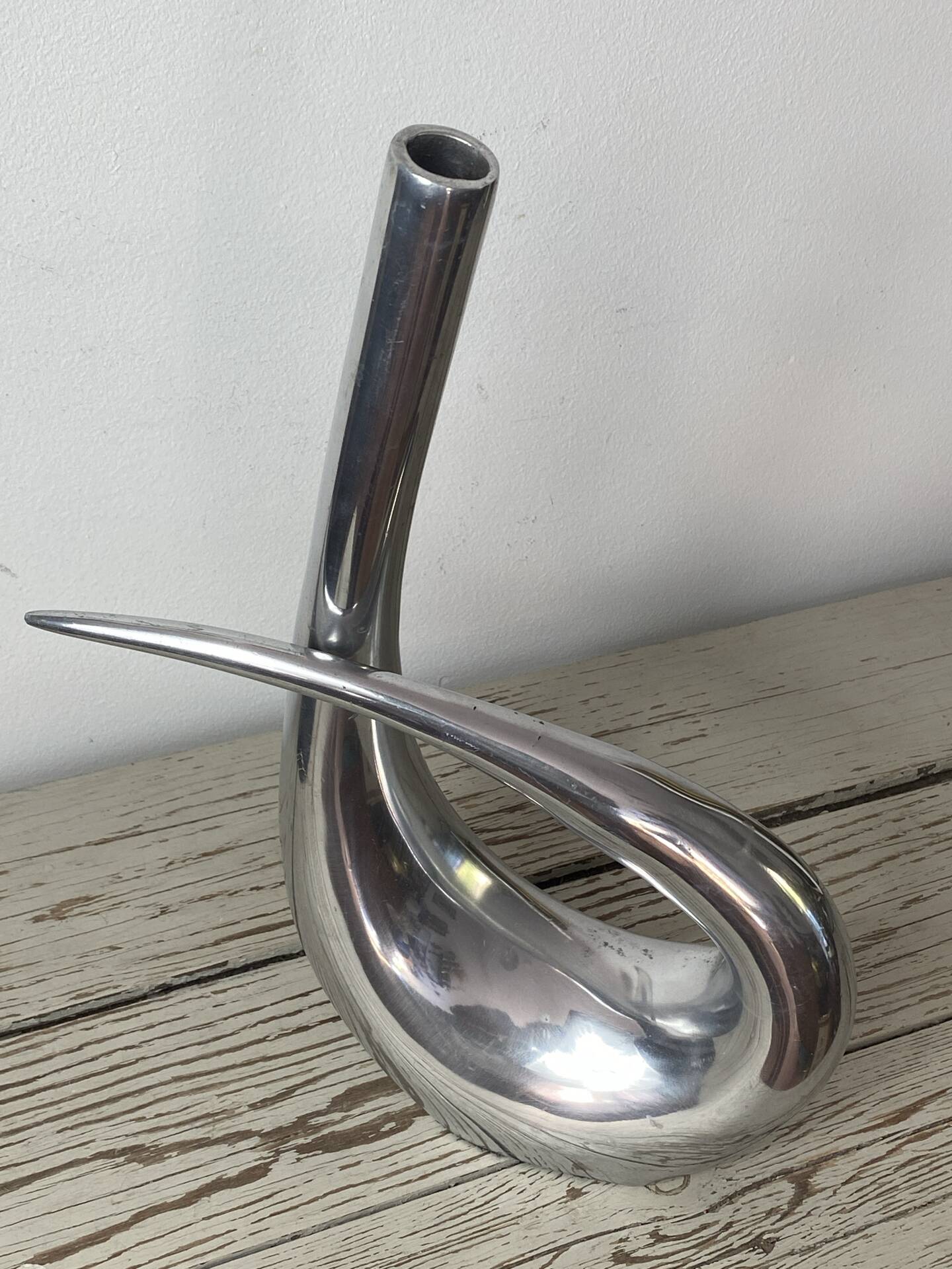 Sculptural vase design in polished aluminium.