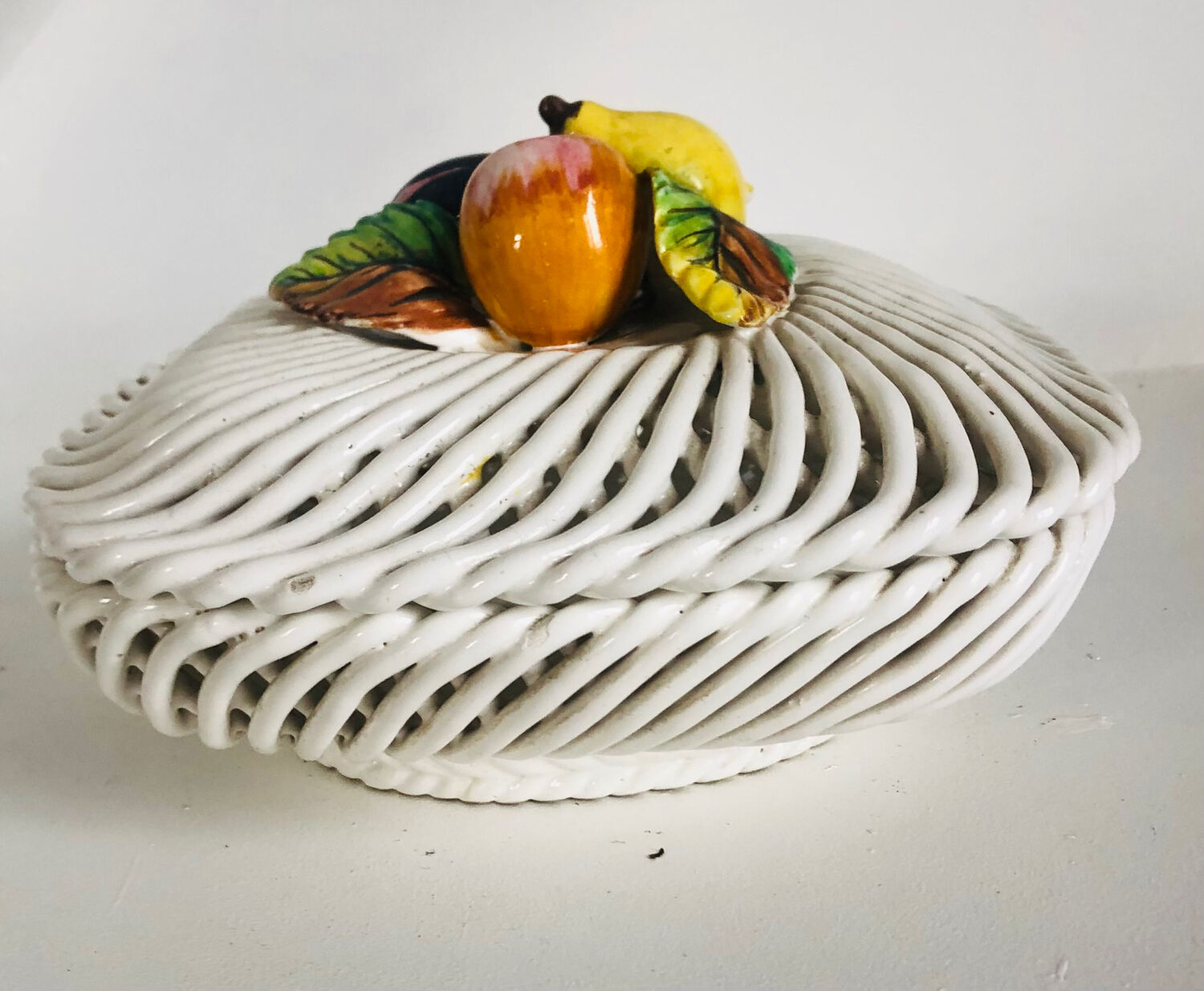 Covered basket in woven ceramic and fruit slip.