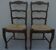 2 stylish solid wood chairs with high backs and straw seats