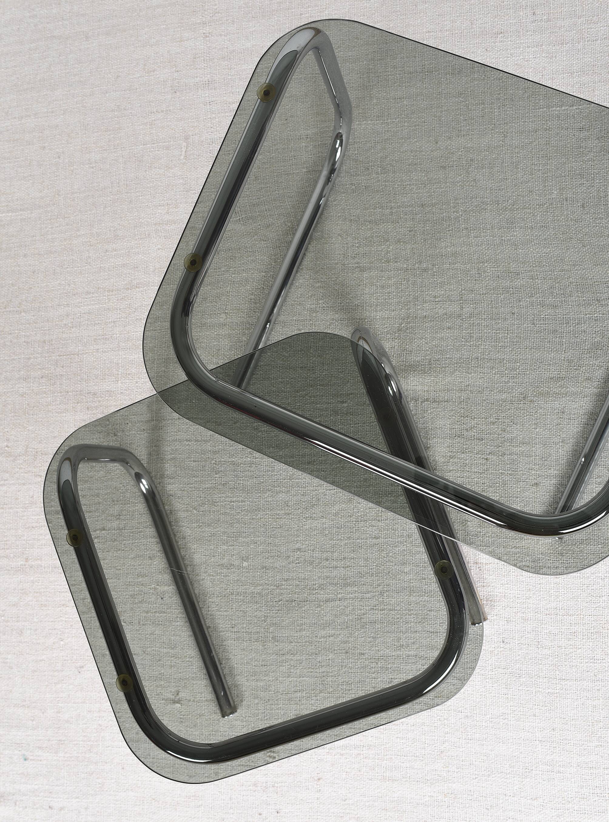Pair of nesting tables in smoked glass and chrome legs.