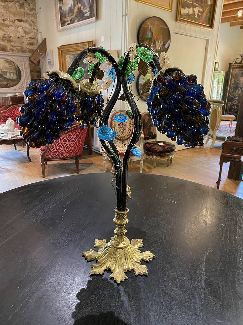 Table lamp with four light arms and globes shaped like bunches of grapes.