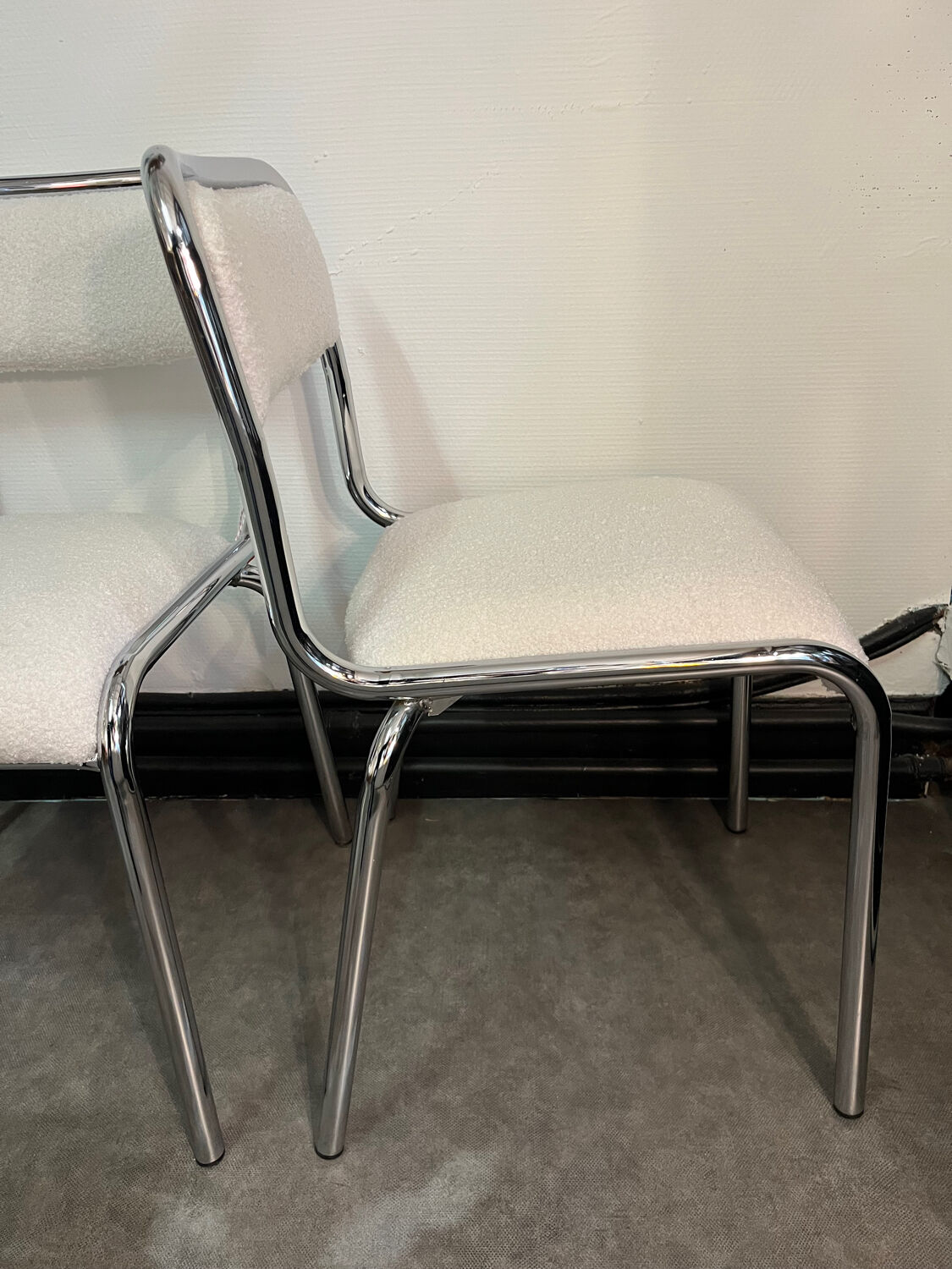 Pair of chrome chairs upholstered in boucle fabric.