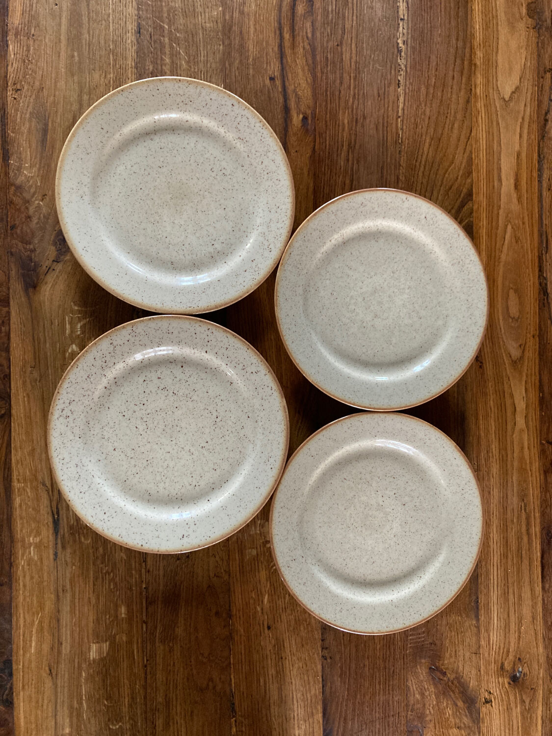 Four beige speckled plates