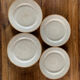 Four beige speckled plates