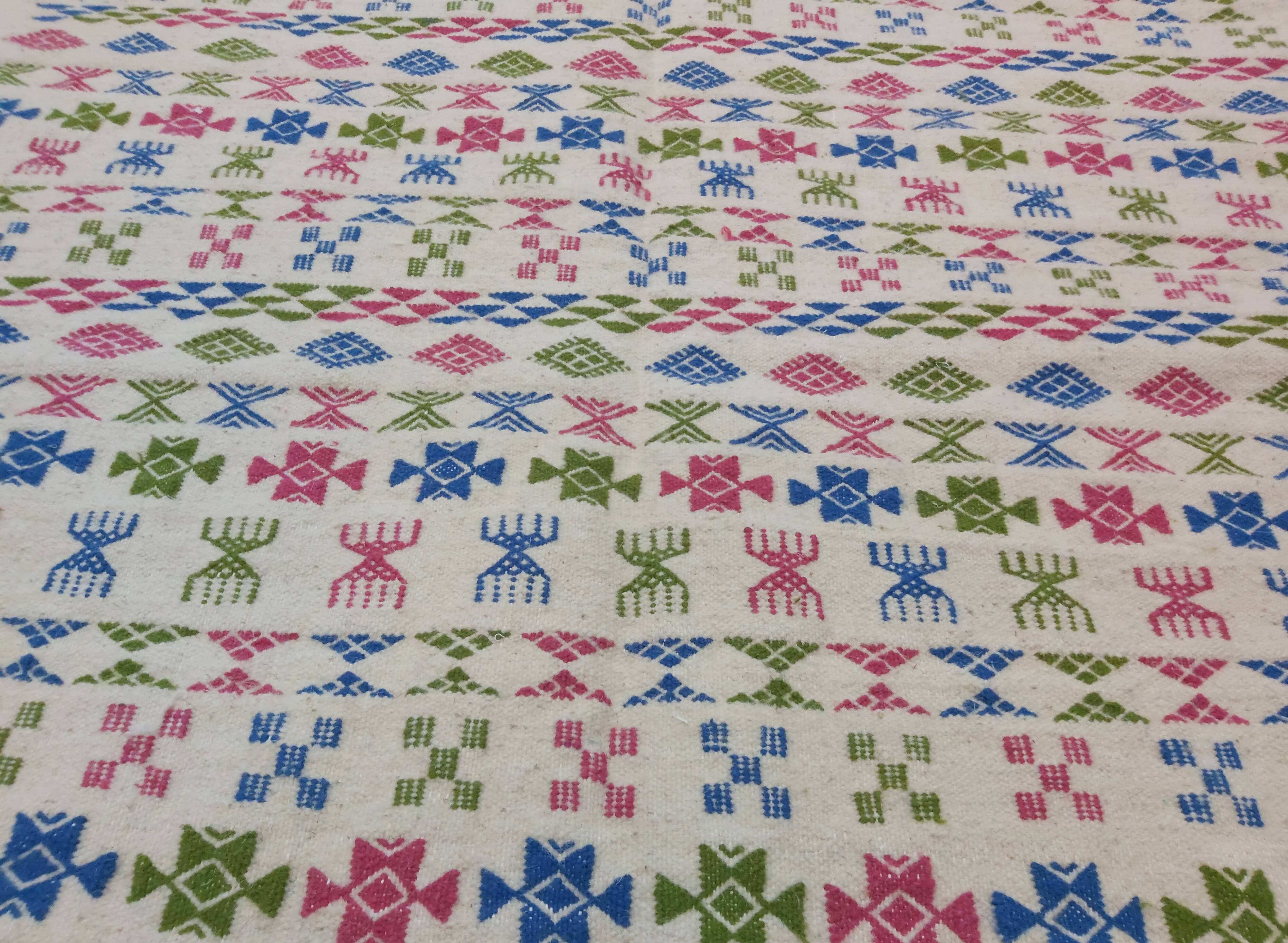 White carpet with Berber motifs pink green and blue