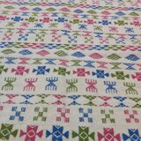Tapis blanc à motifs berbères rose vert et bleu