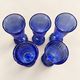 Set of 5 blue glass champagne flutes with faceted stems.
