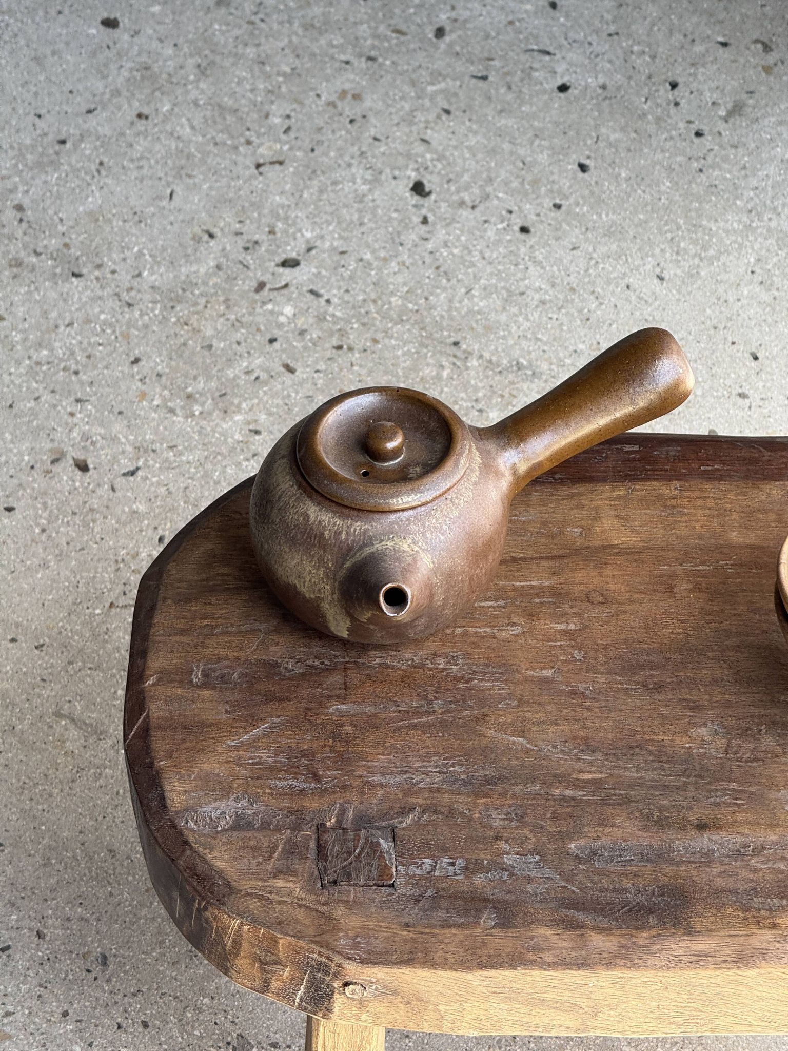 Small stool, oval solid teak side table with curved legs in wabi-sabi style.