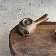 Small stool, oval solid teak side table with curved legs in wabi-sabi style.