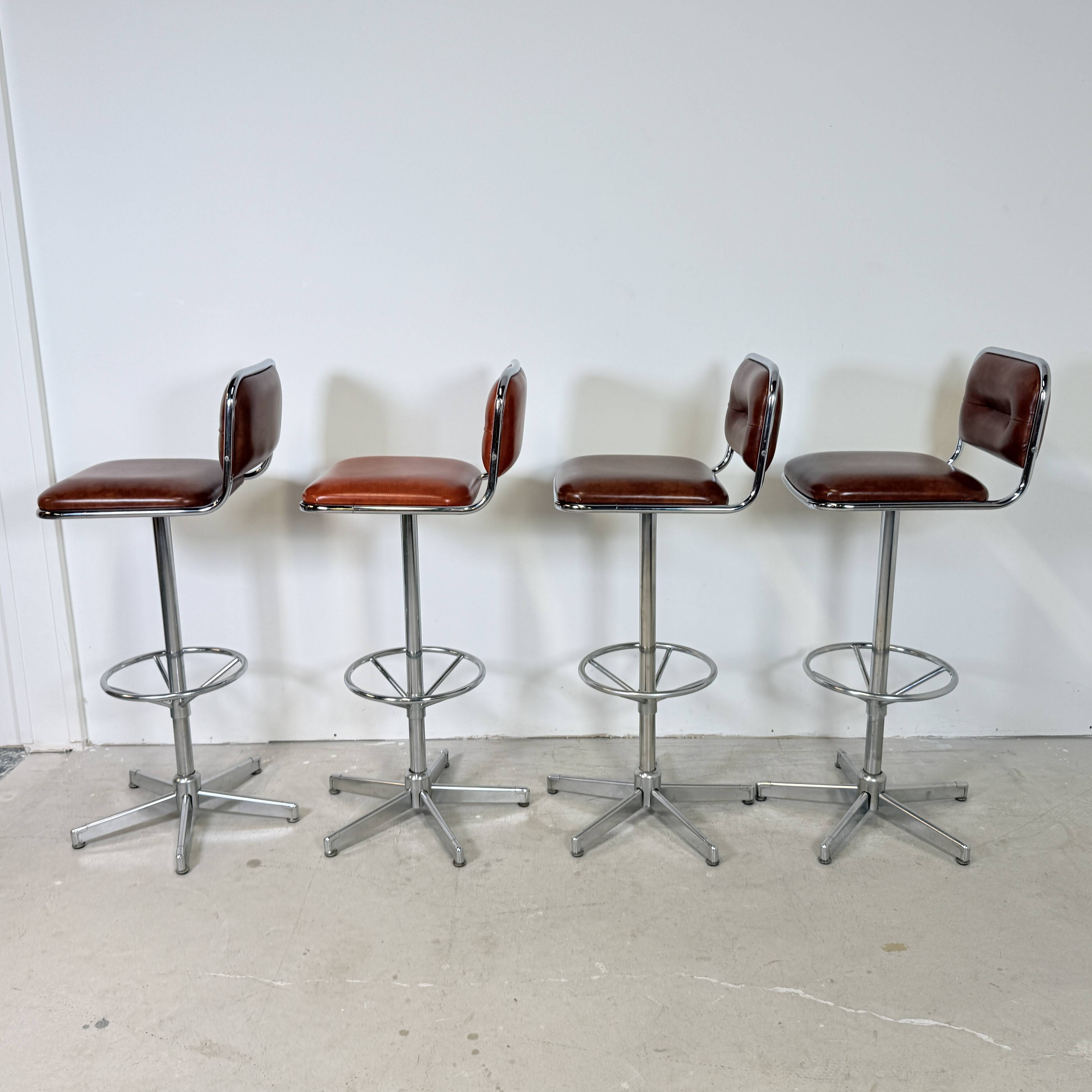1970s chrome bar stools with cognac-colored faux leather upholstery