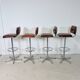 1970s chrome bar stools with cognac-colored faux leather upholstery