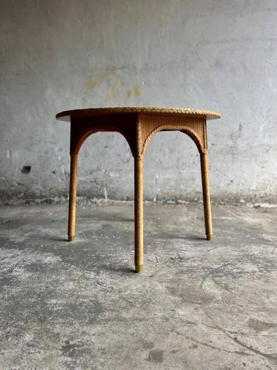 Natural Lloyd Loom paper cord rattan round table with brass-capped legs by Vincent Sheppard