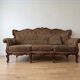 Classic 3-seater sofa in brown fabric and wood.