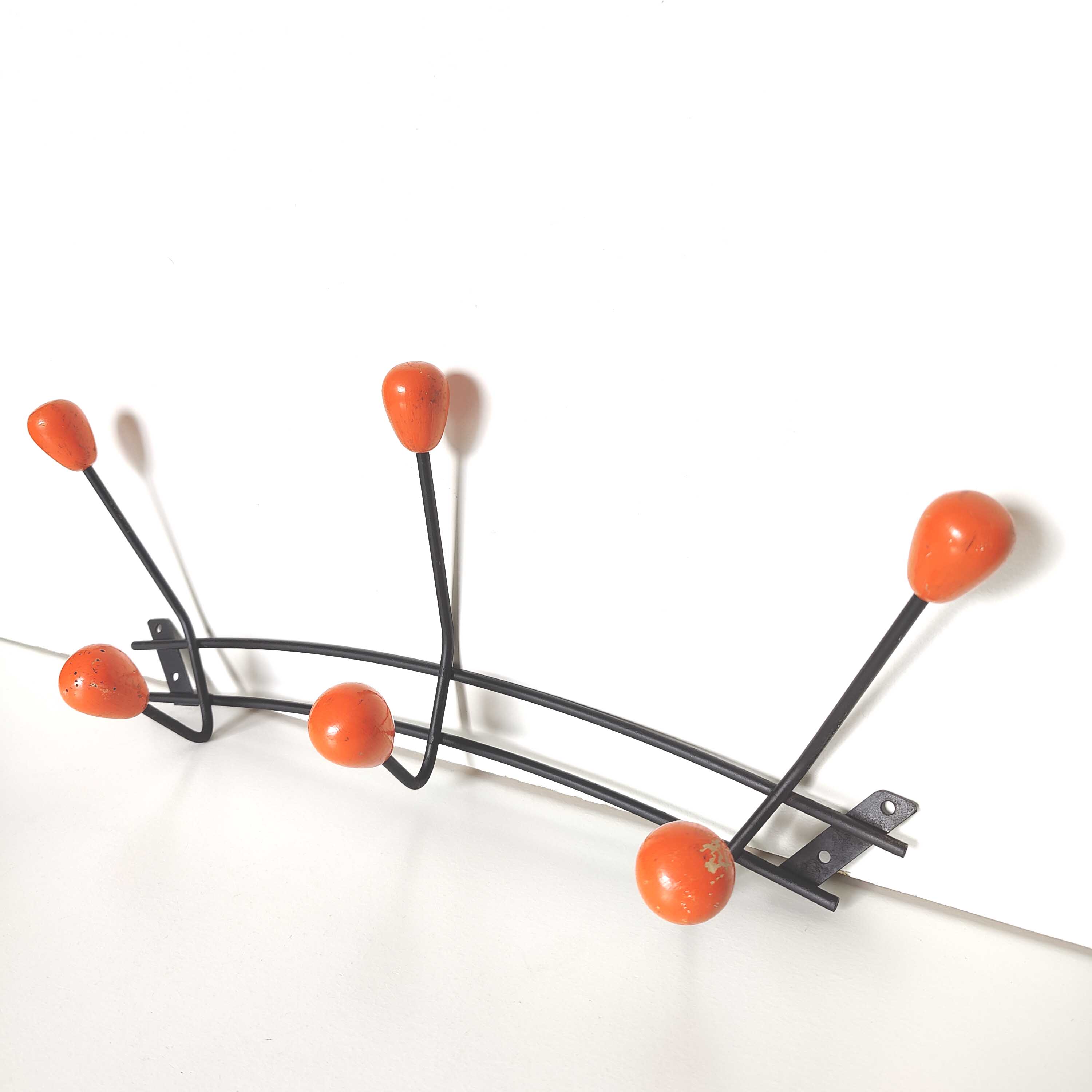 Black metal coat rack and orange wood balls