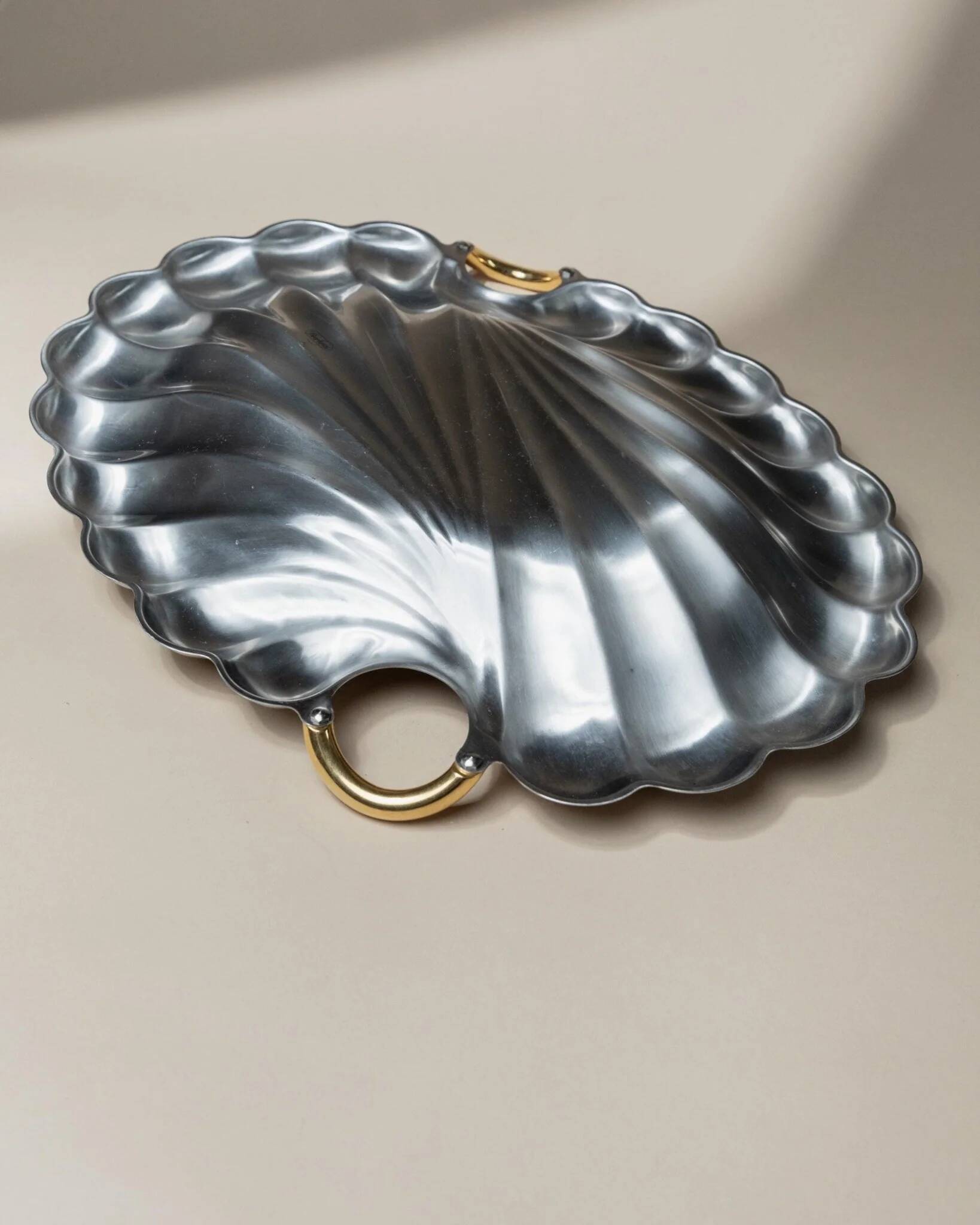 Plateau en acier inoxydable poli argenté en forme de coquillage avec poignées dorées, Becchetti Italie années 1980.