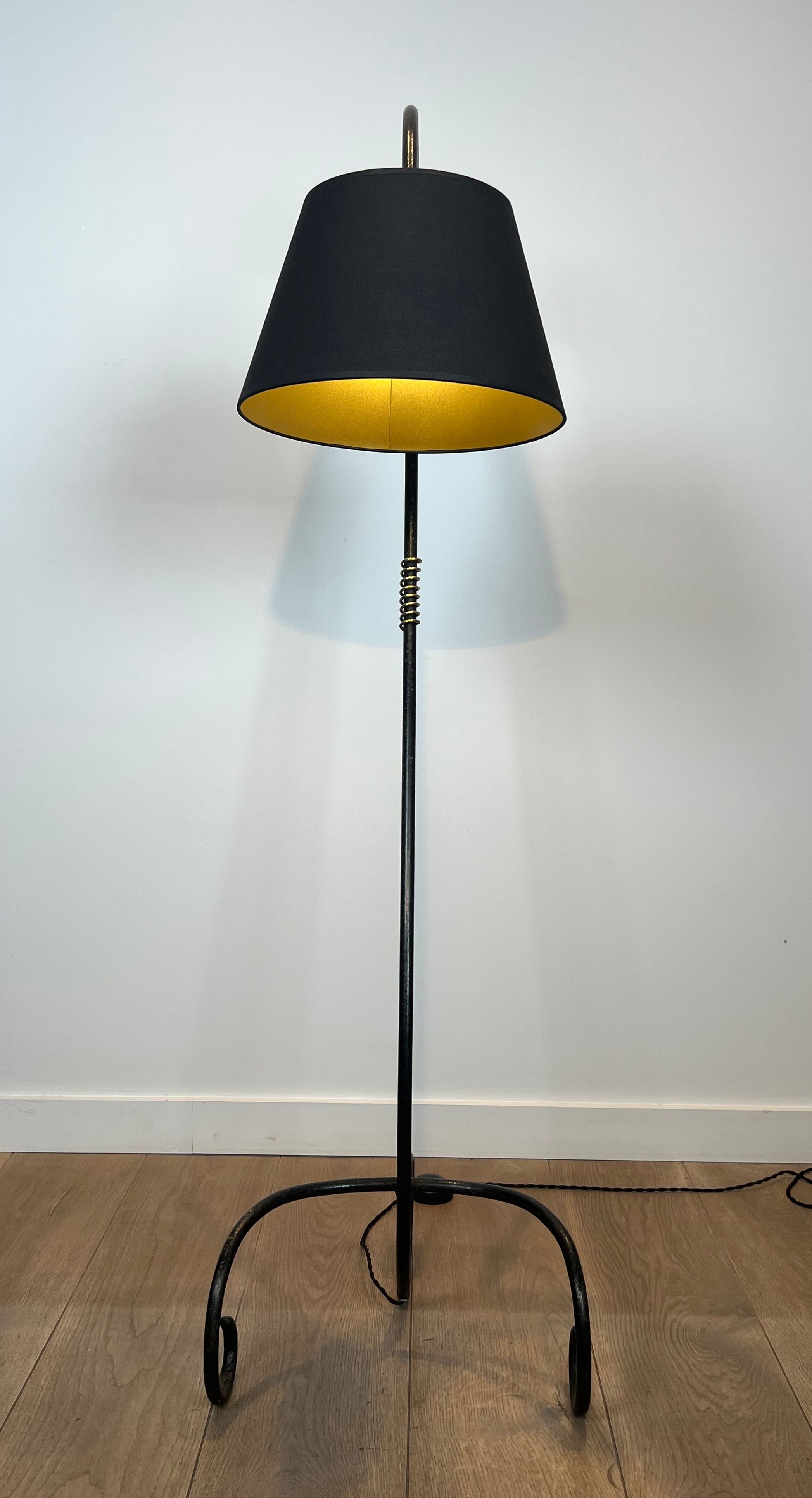 Design floor lamp in black lacquered metal and brass.