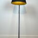 Design floor lamp in black lacquered metal and brass.