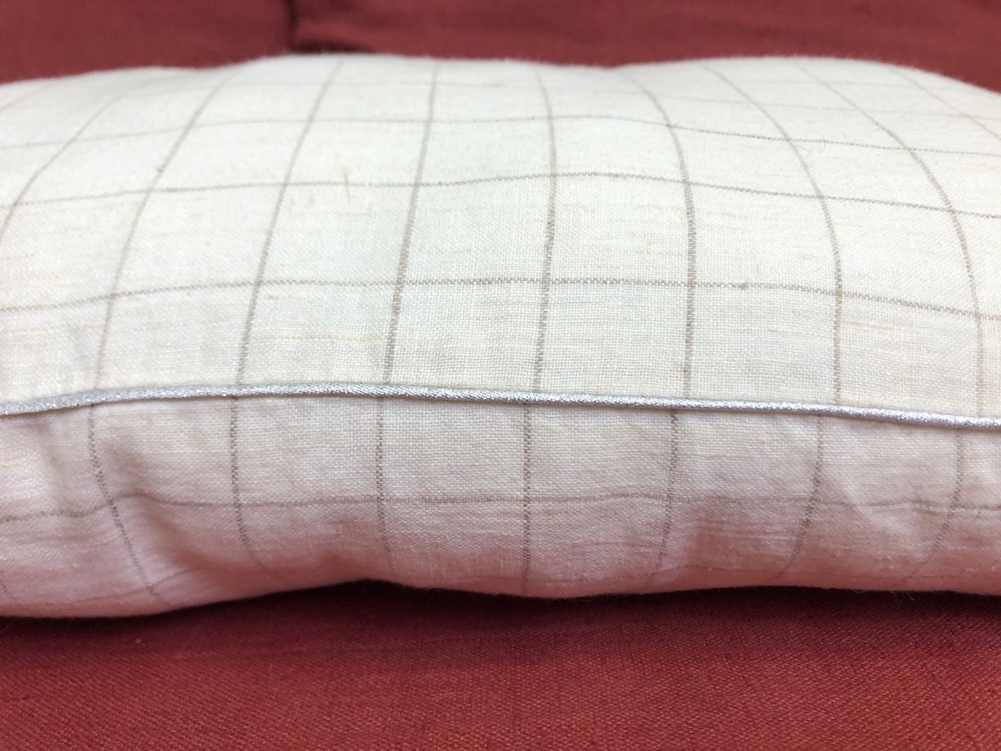 Beige linen cushion with checkered pattern and shiny silver piping