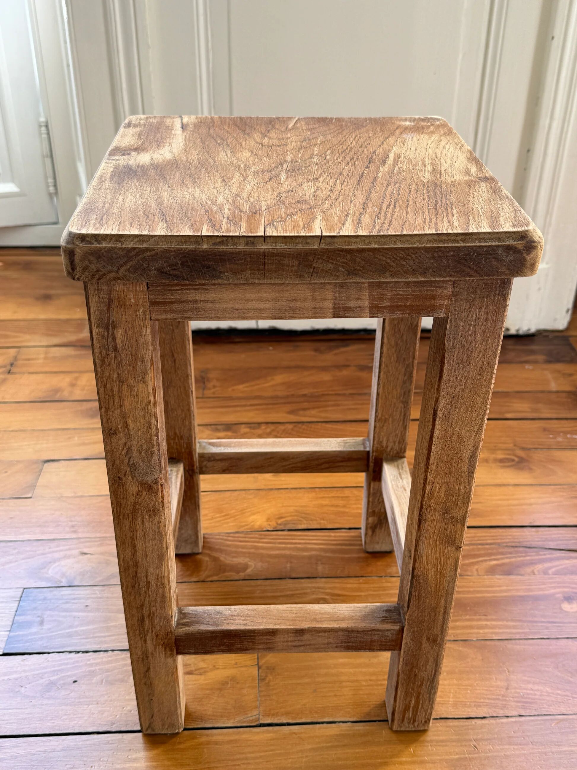 Brutalist stool in raw wood with a weathered effect.