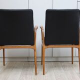 Suite de 2 fauteuils en cuir noir et bois