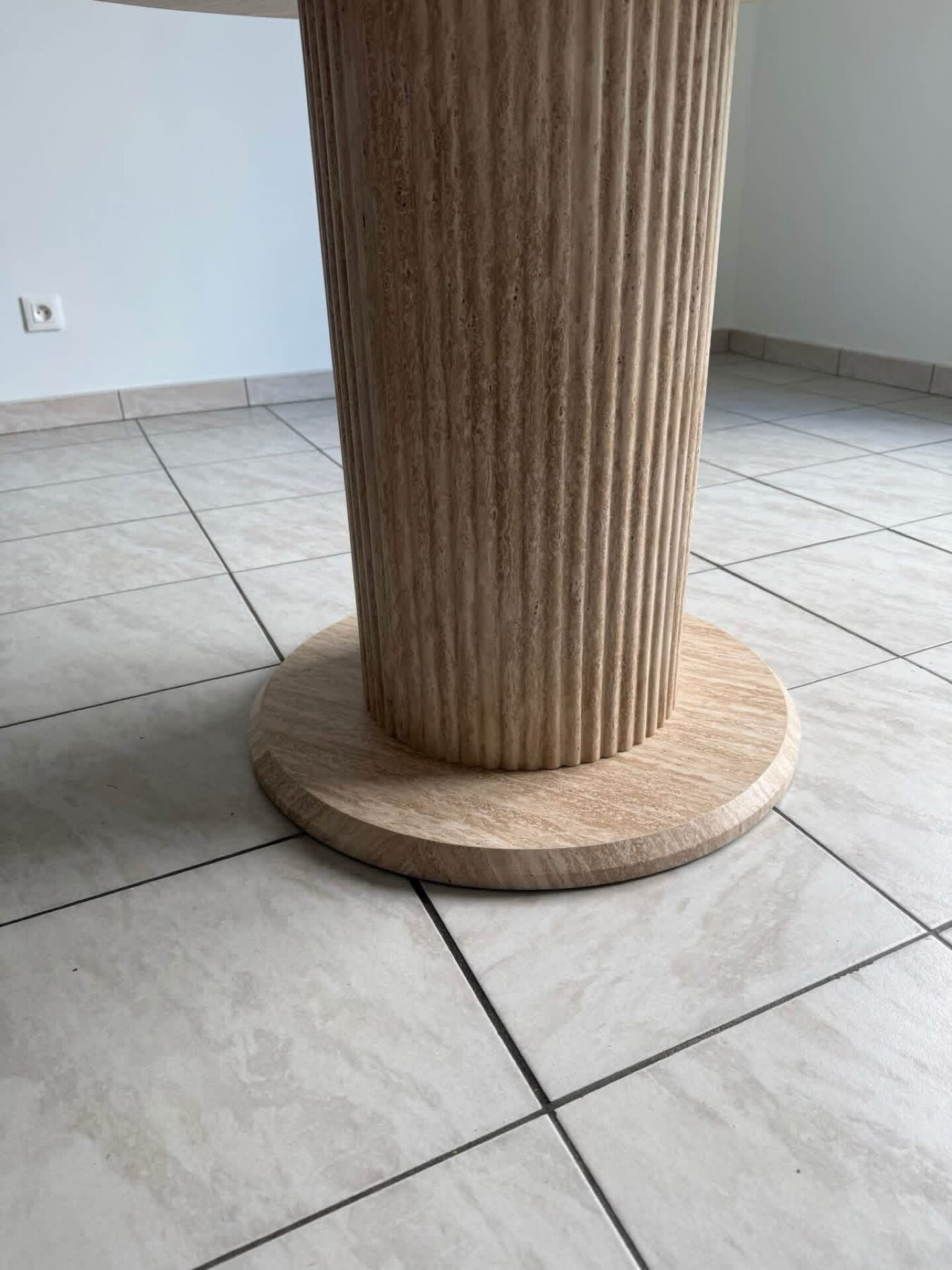 Round table with a travertine effect.