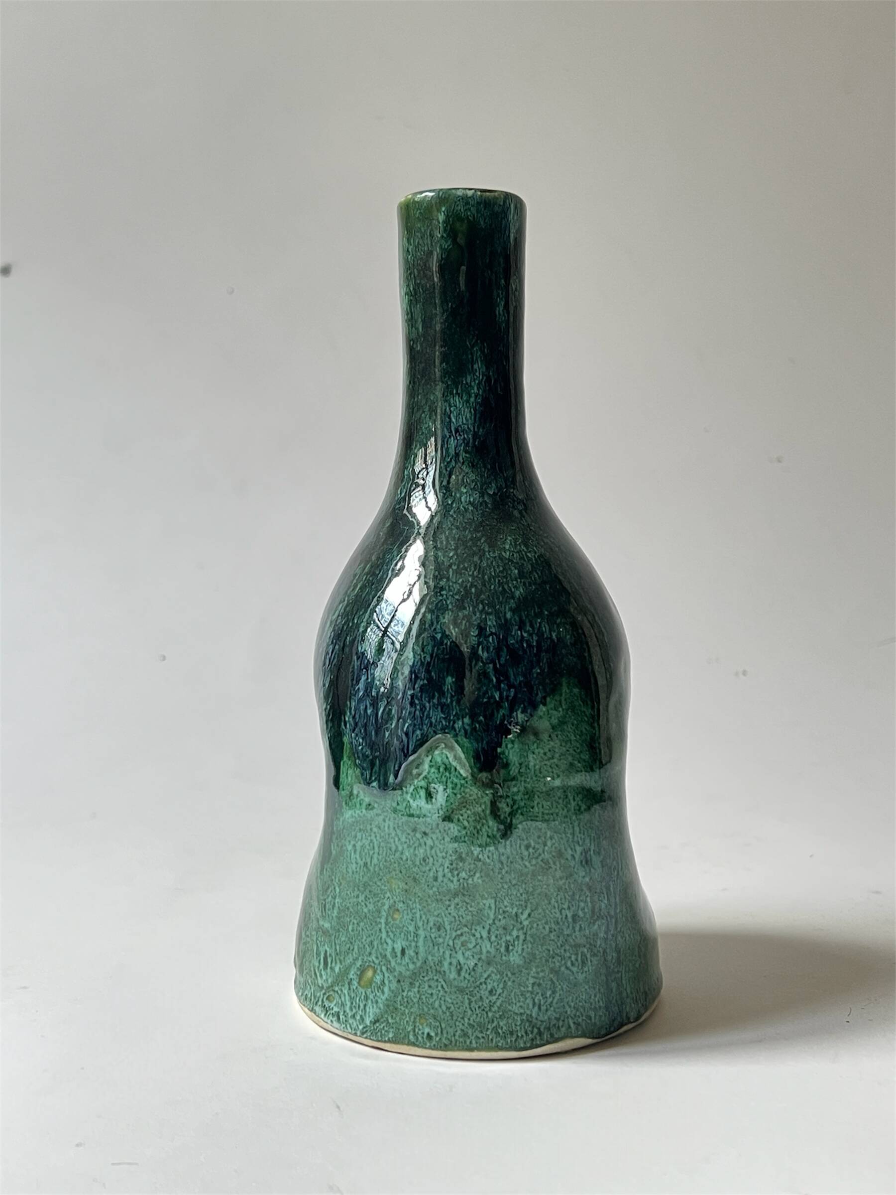 Ceramic vase with a glazed blue/green finish.