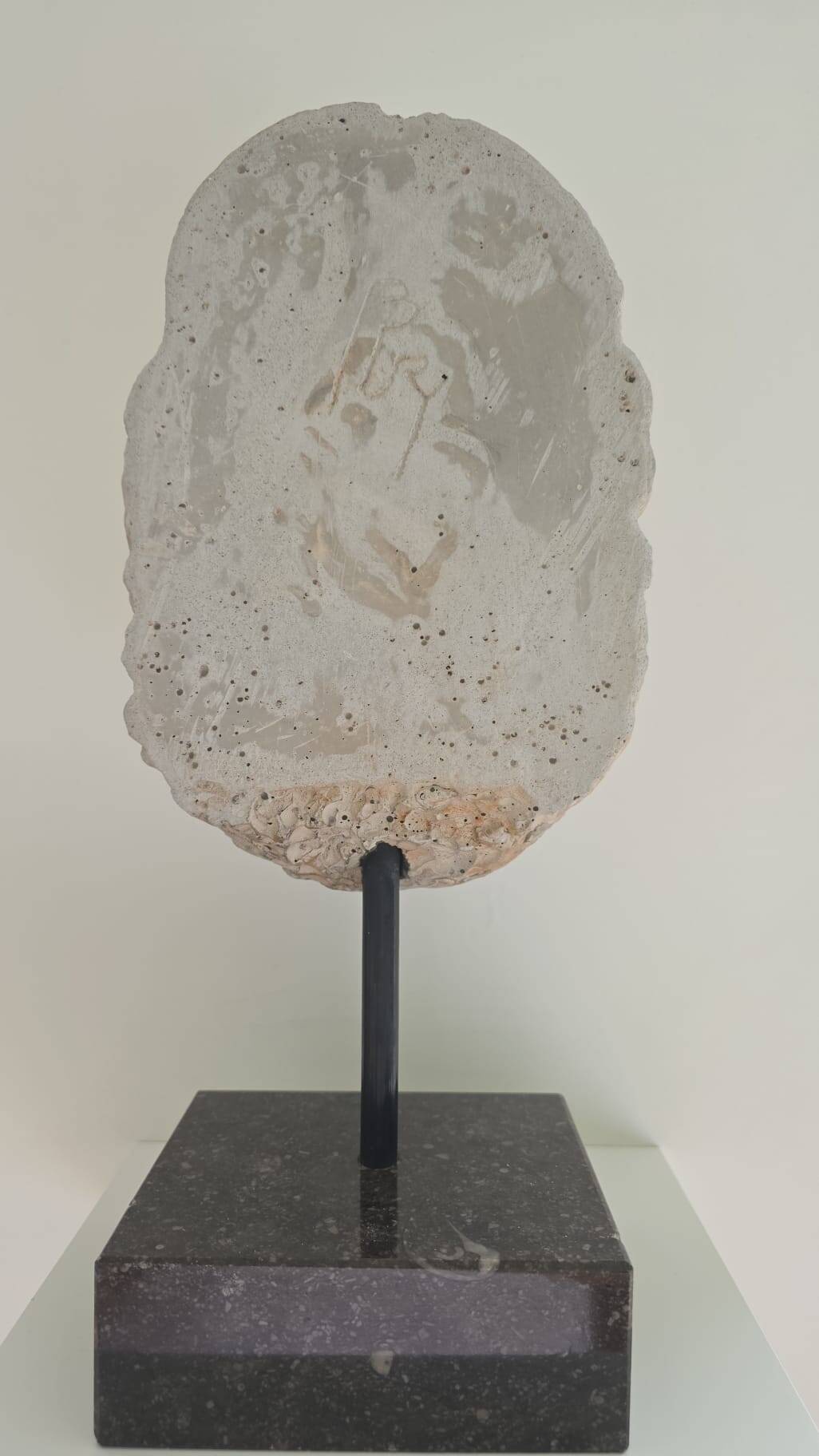 Greek god statue in stone with a marble base.