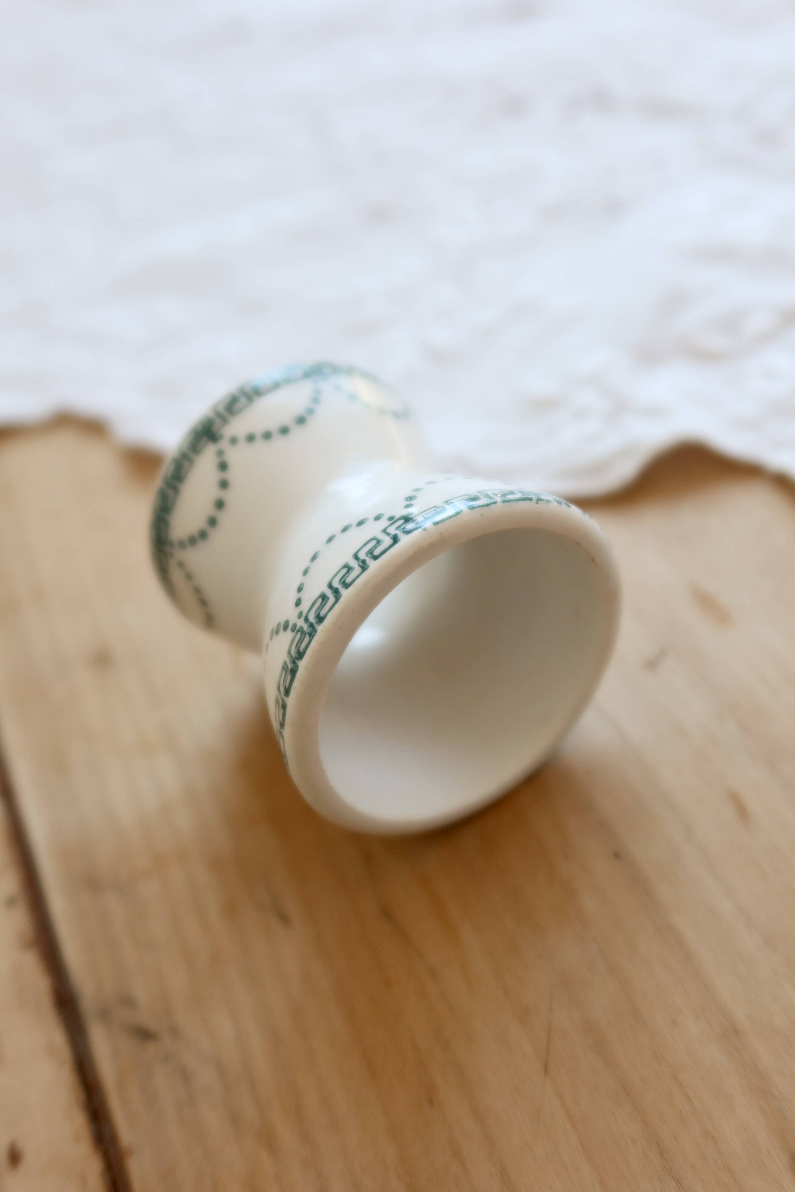 Old diabolo egg cup, ironstone with ivory and green pattern.