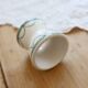 Old diabolo egg cup, ironstone with ivory and green pattern.