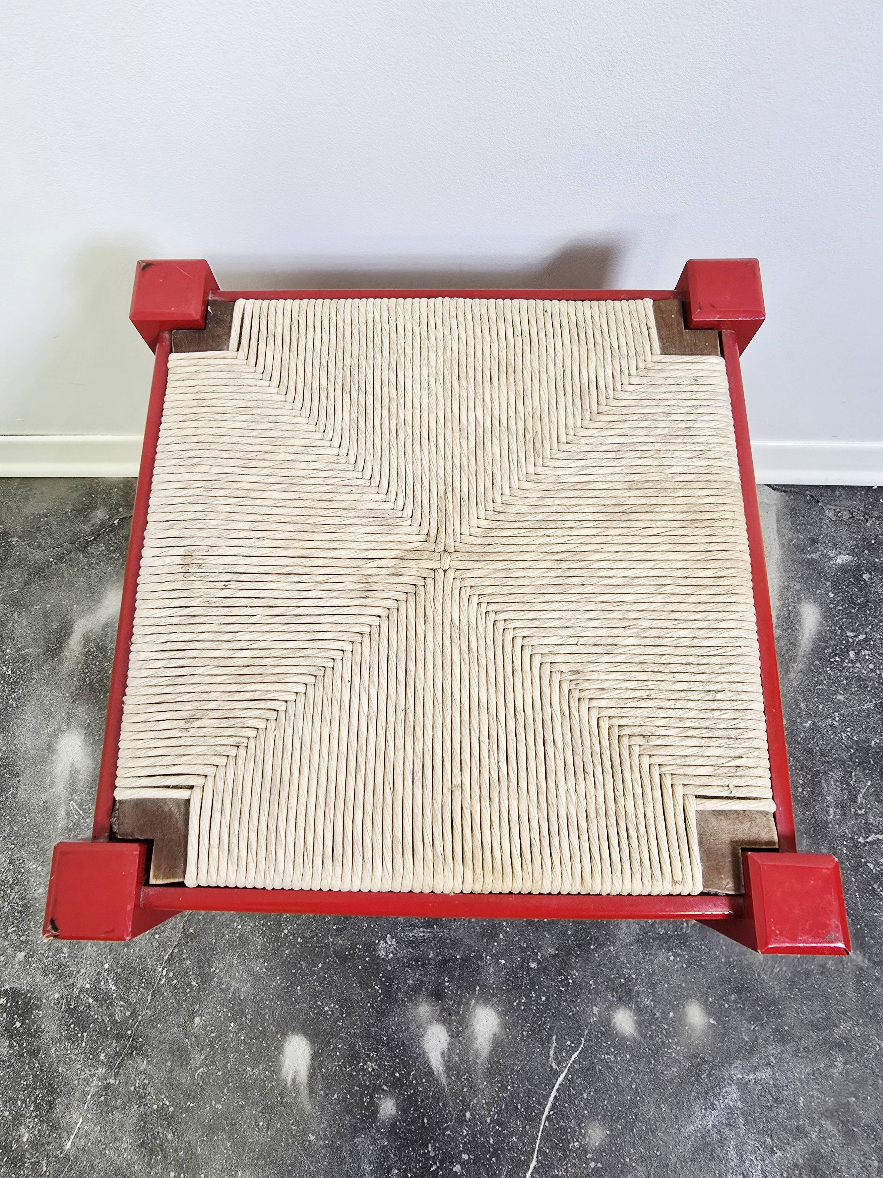 Red wooden stool with woven rush seat.