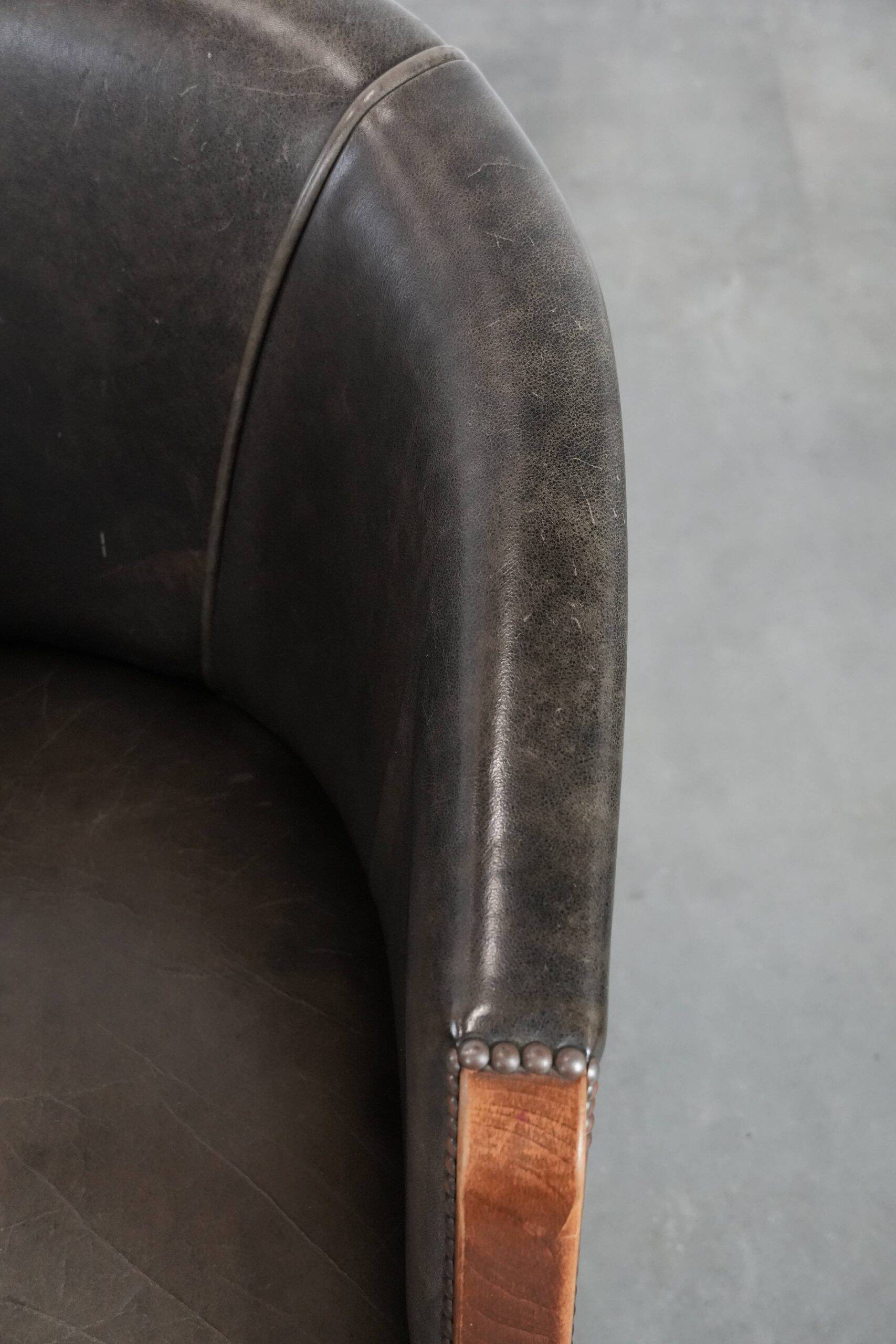 Set of two cowhide and wooden tub chairs with a sturdy colour scheme