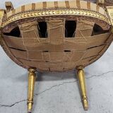 A pair of gilded wooden armchairs in the Louis XVI style.