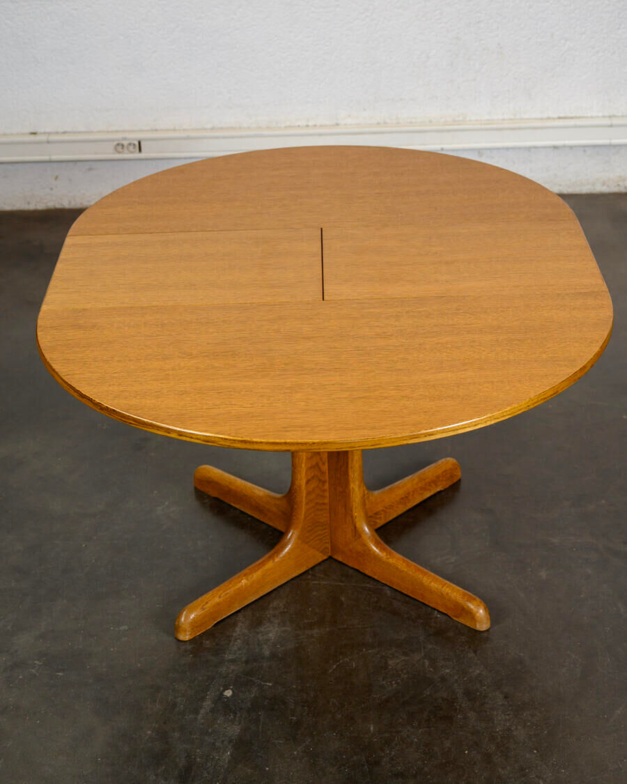 Round teak table with an extension.